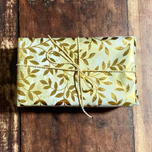 Load image into Gallery viewer, Gift wrapped parcel with gold leafy paper and recycled cream cord 
